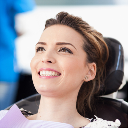 Smiling woman sitting in a dental chair, appearing confident after receiving a second opinion.